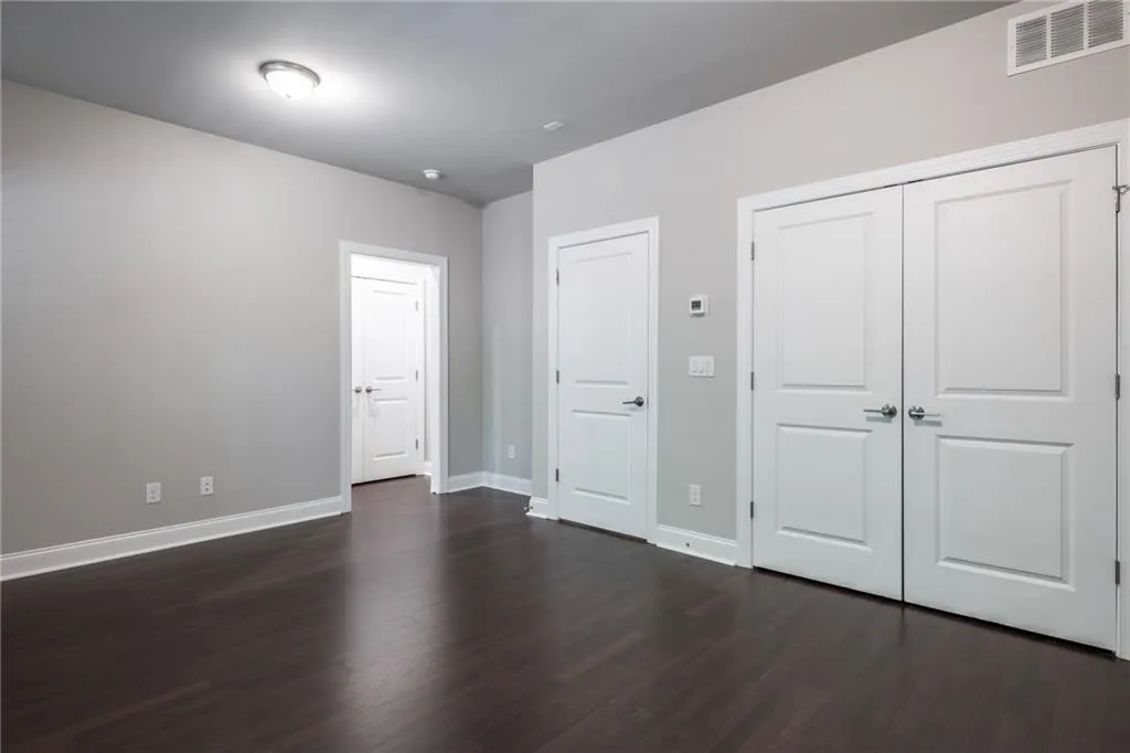 Unfurnished bedroom with dark wood finished floors and a closet
