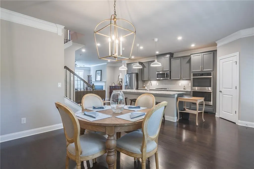 Dining space with a chandelier, dark wood finished floors, recessed lighting, stairway, and ornamental molding
