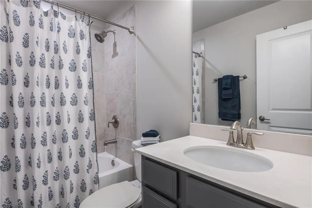 Full bathroom featuring vanity and shower / bath combination with curtain