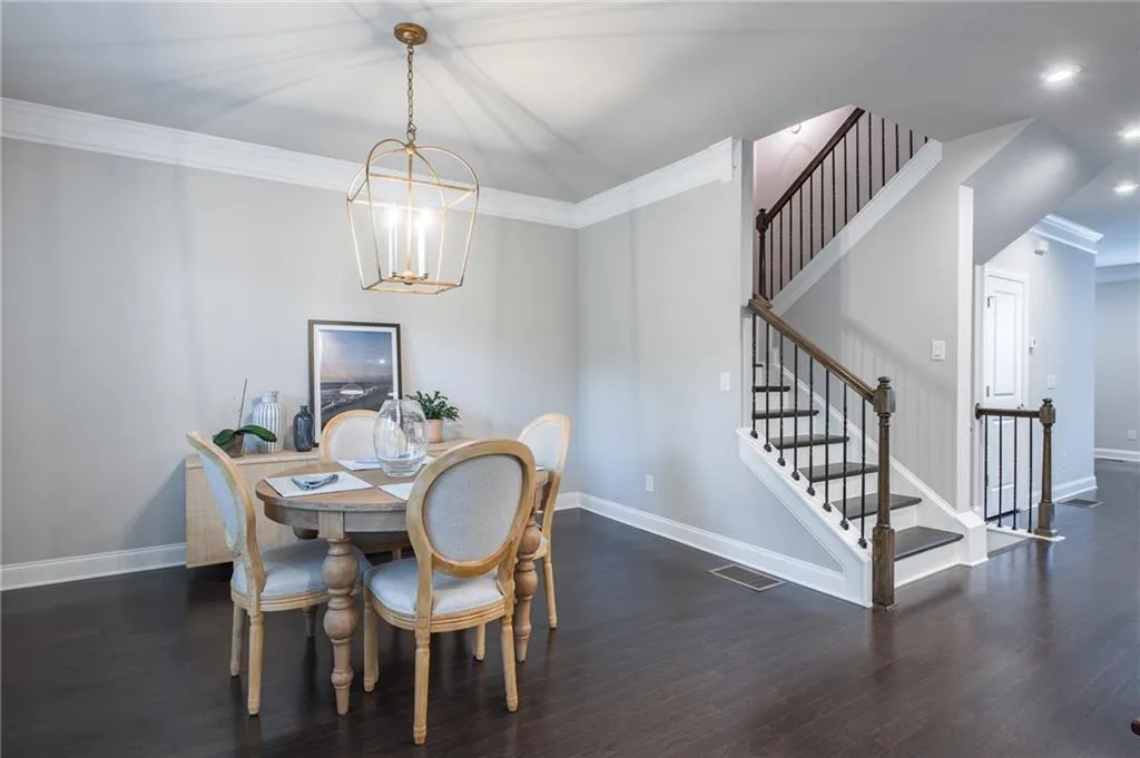 Dining area with wood finished floors, crown molding, a chandelier, stairs, and recessed lighting