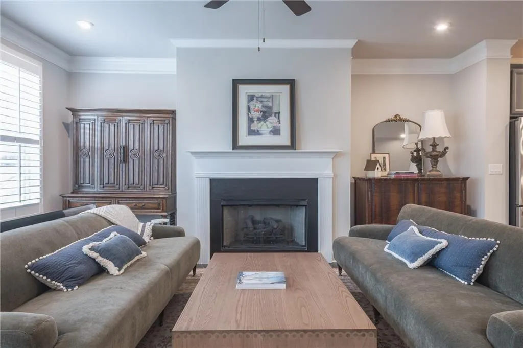 Living area with crown molding, a ceiling fan, healthy amount of natural light, a fireplace, and recessed lighting