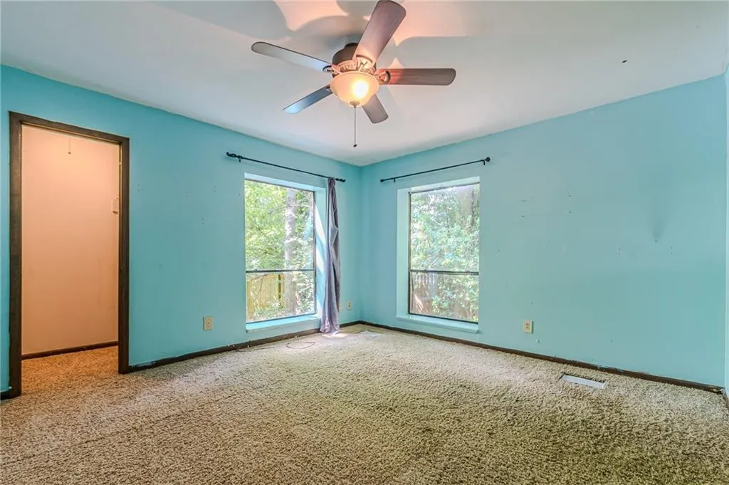 Empty room with carpet floors and ceiling fan