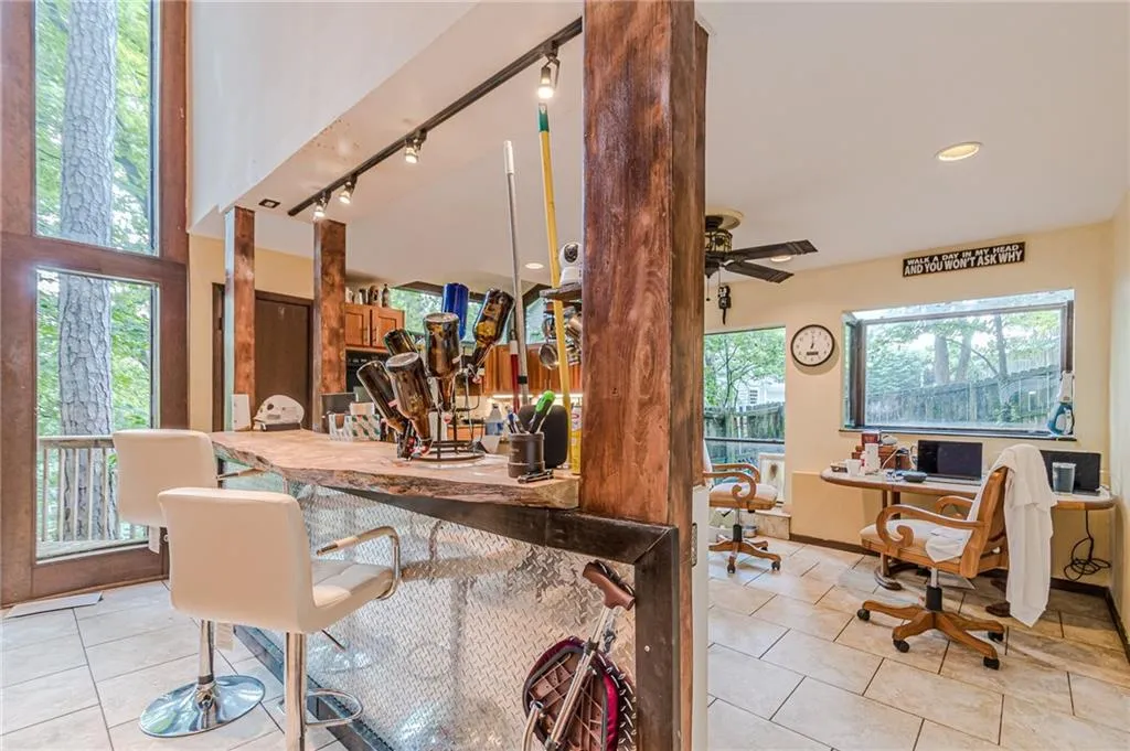 Tiled dining area featuring ceiling fan, track lighting, and plenty of natural light