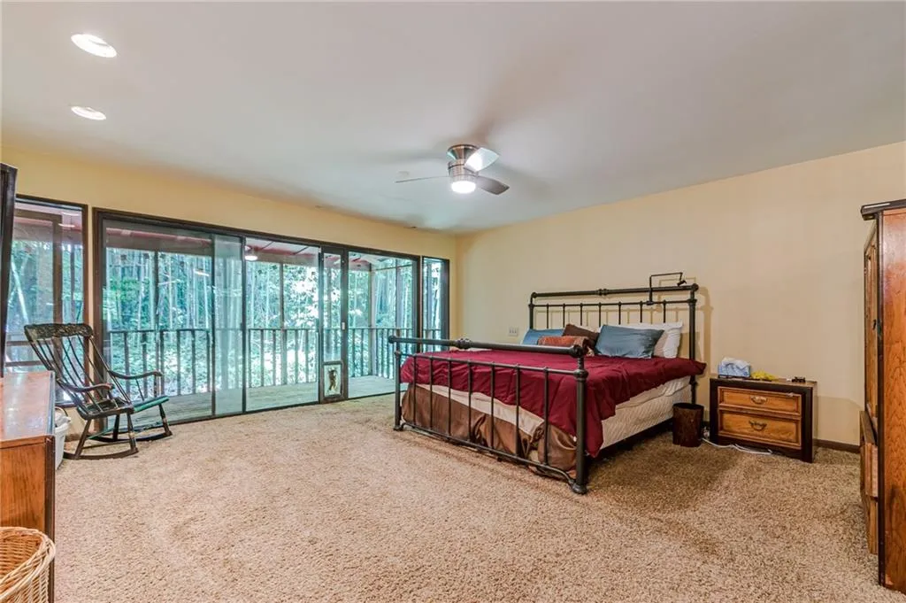 Carpeted bedroom with access to exterior and ceiling fan