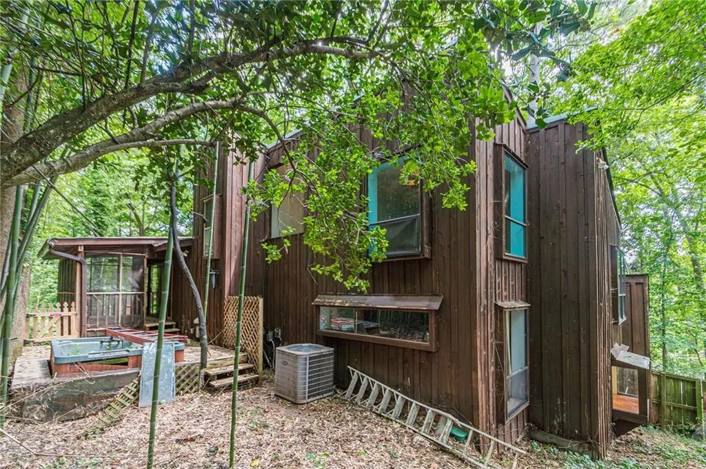 View of property exterior featuring central AC and a wooden deck
