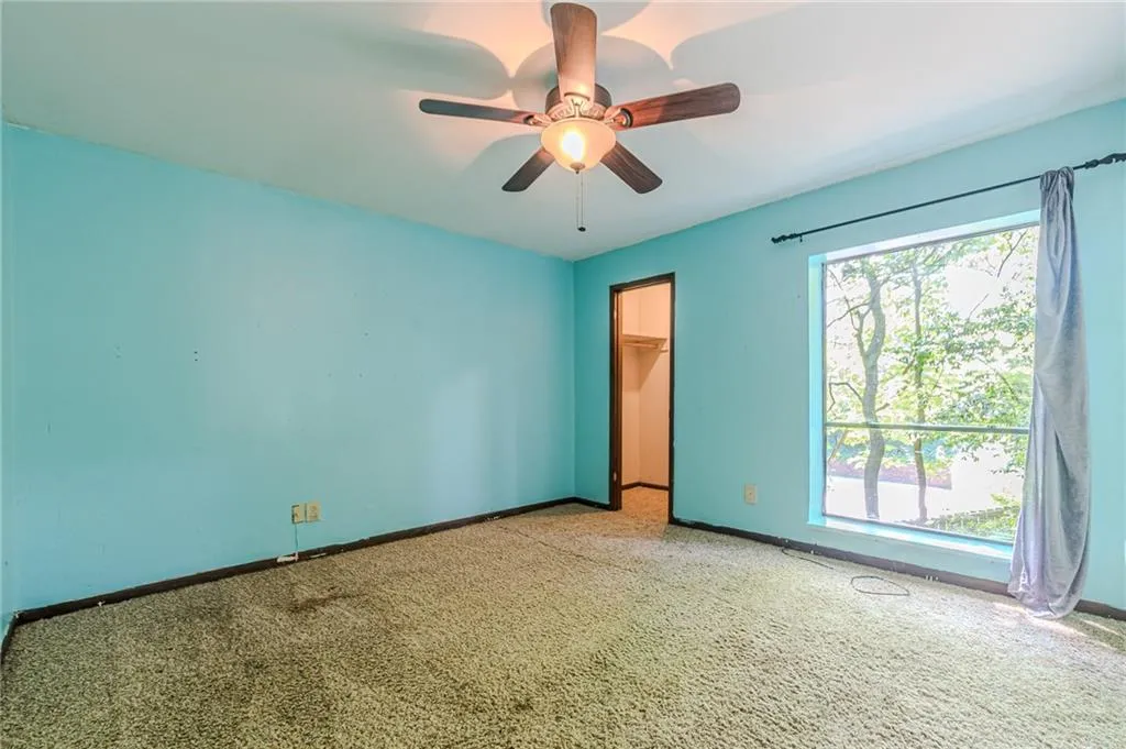 Unfurnished room with carpet flooring, a wealth of natural light, and ceiling fan