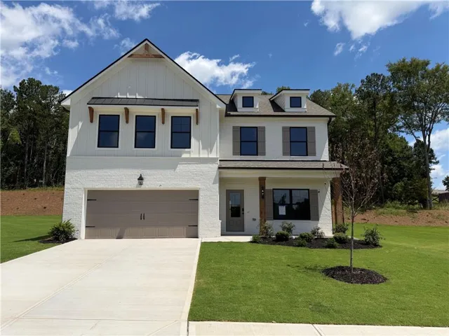 Modern farmhouse exterior featuring white brick and vertical siding