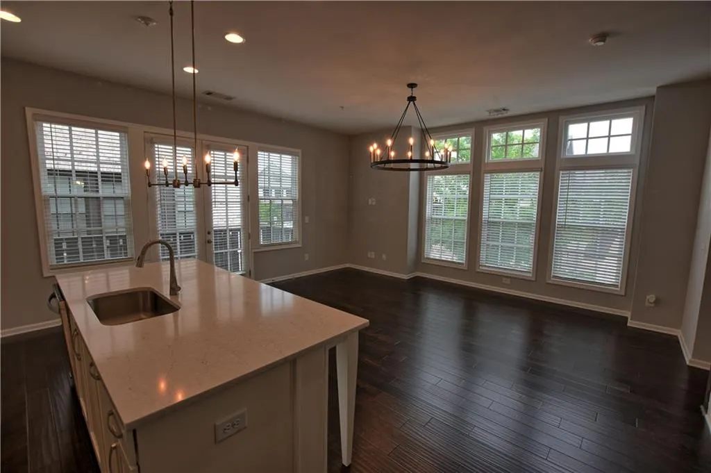 Kitchen with baseboards, a chandelier, a sink, and visible vents