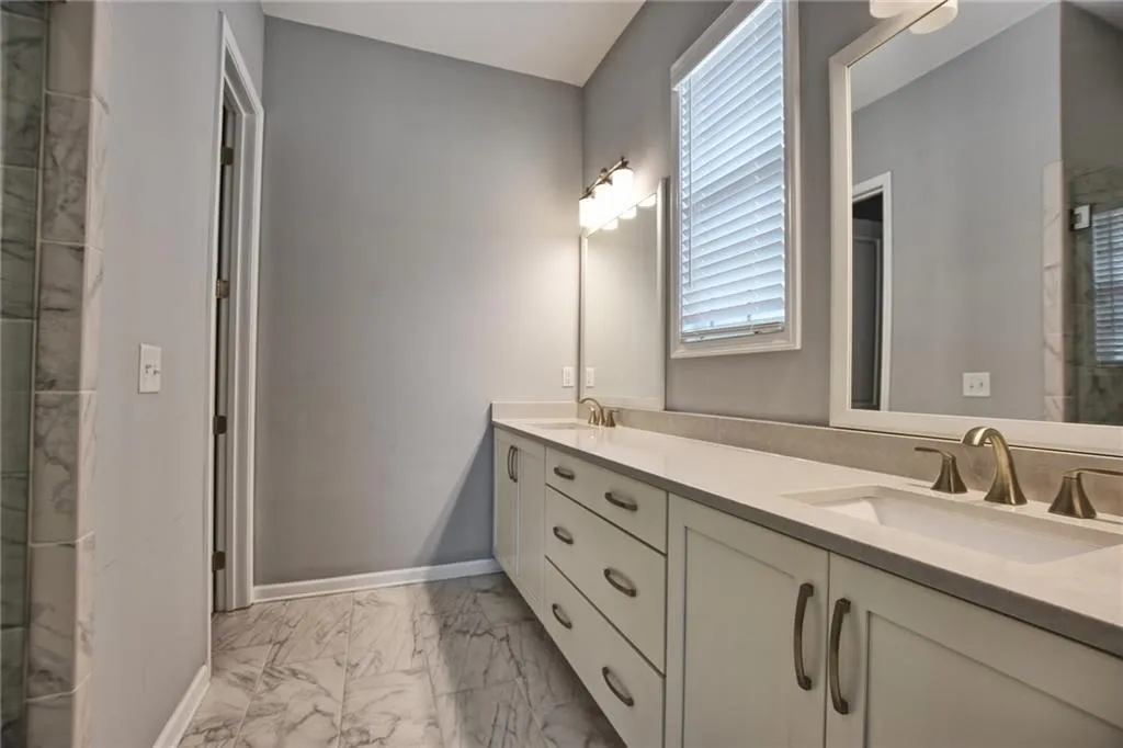 Bathroom with a sink, a healthy amount of sunlight, and marble finish floor