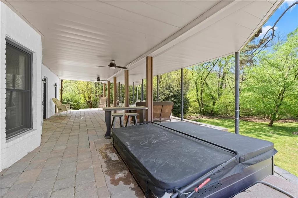 Covered stone patio with a built-in hot tub and under-deck drainage system