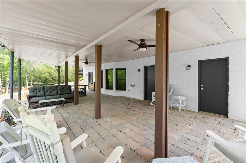 Covered stone patio with a built-in hot tub and under-deck drainage system