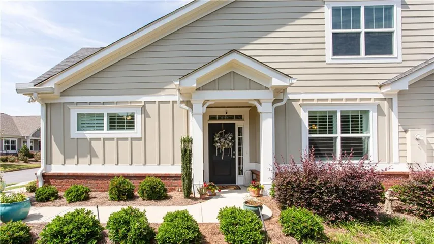 Light-colored siding with white trim accents and a covered entry