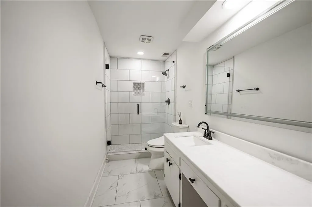 Bathroom with vanity, a stall shower, light marble finish floors, and recessed lighting
