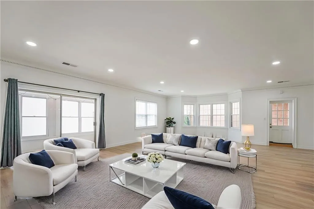 Living room featuring healthy amount of natural light, light wood-style flooring, recessed lighting, and crown molding