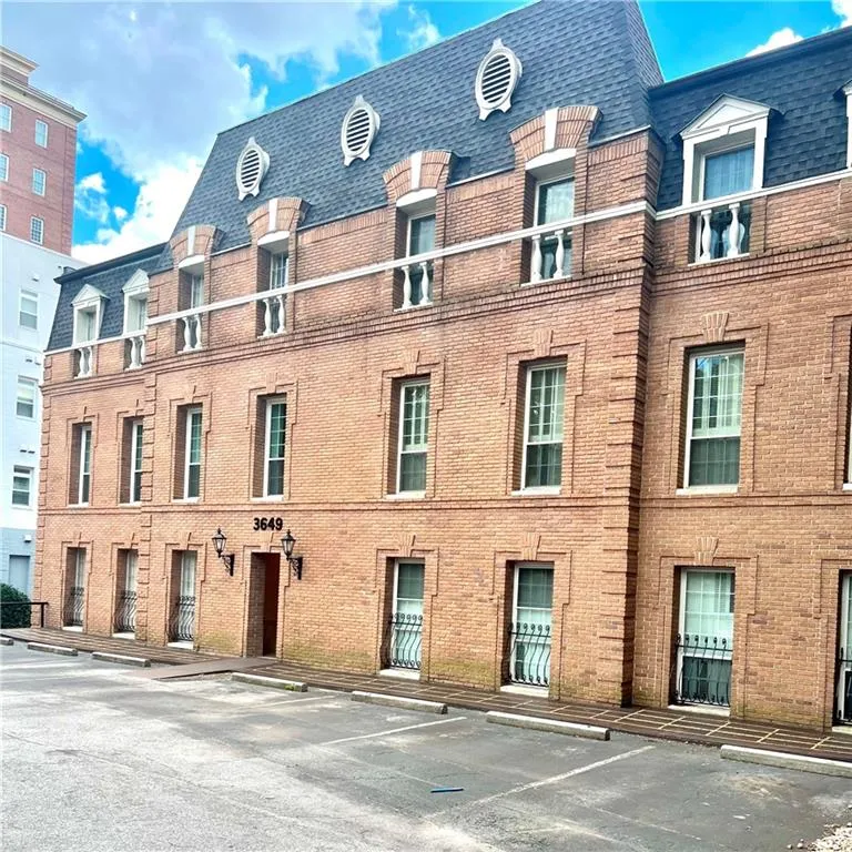 View of building exterior with uncovered parking