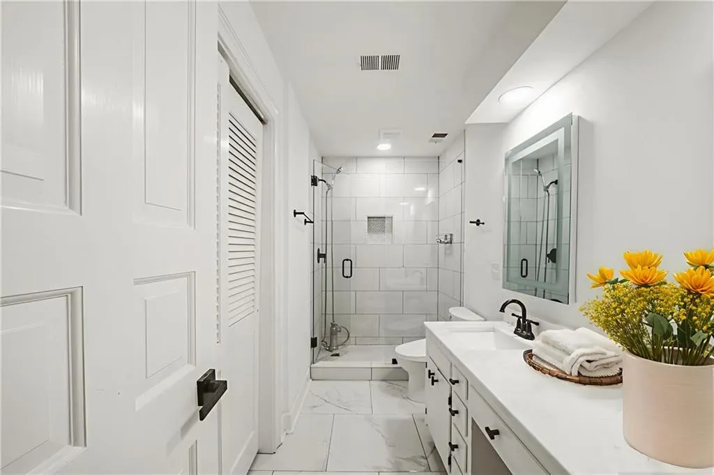 Bathroom with a stall shower, vanity, and marble finish flooring