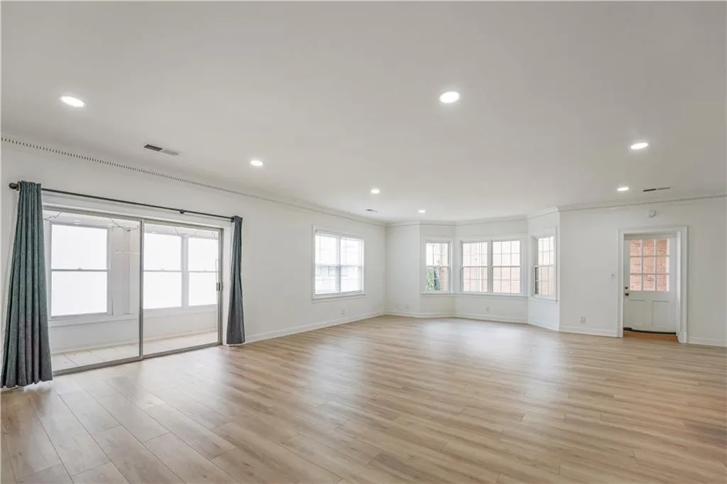 Empty room with ornamental molding, recessed lighting, and light wood-type flooring