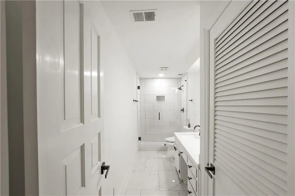 Full bathroom with a closet, vanity, a shower stall, and light marble finish floors