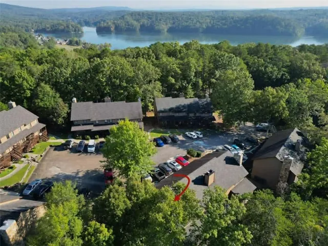 Property situated among mature trees with a lake backdrop