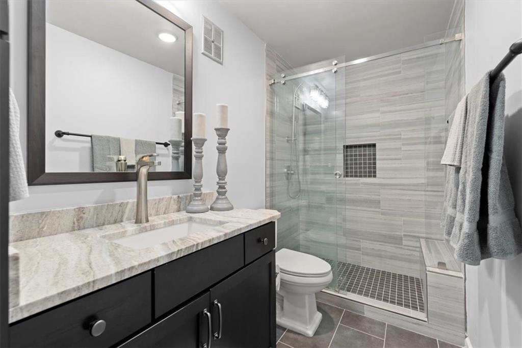 Primary bathroom with walk-in tile shower with bench