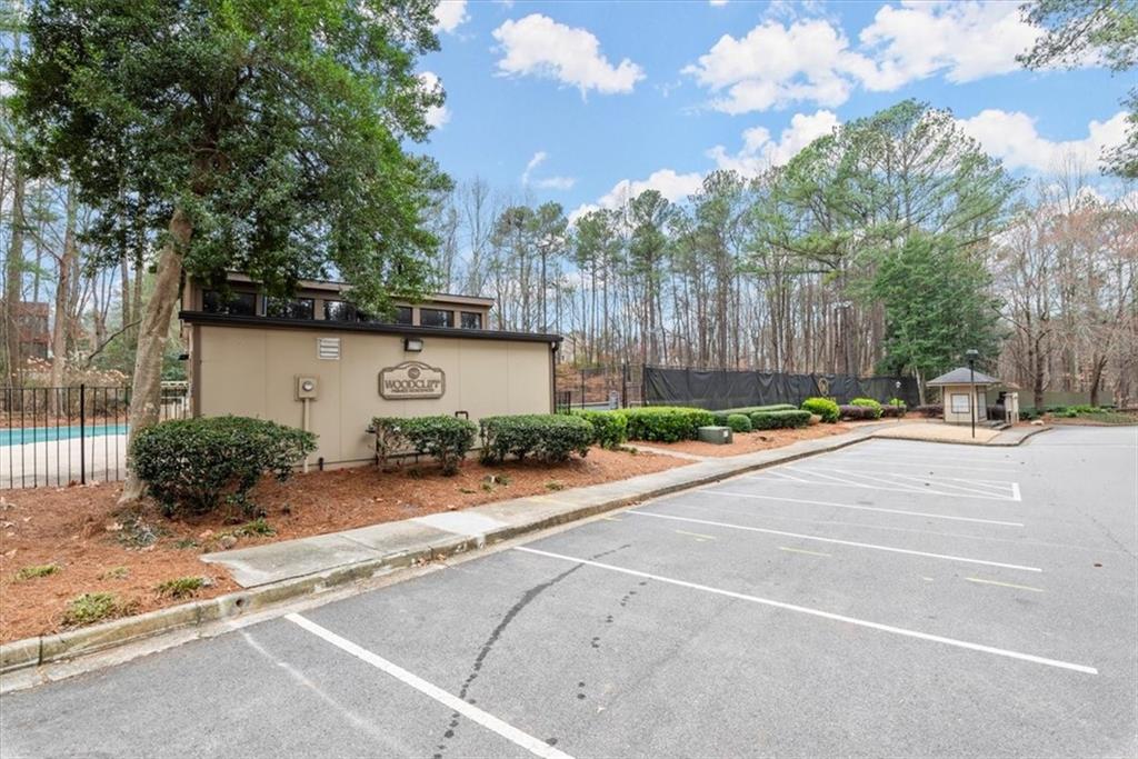View of car parking with a fenced in pool