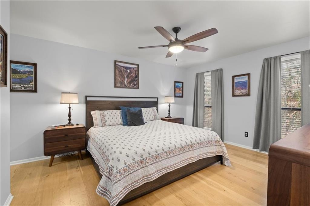 Bedroom with ceiling fan and wood flooring