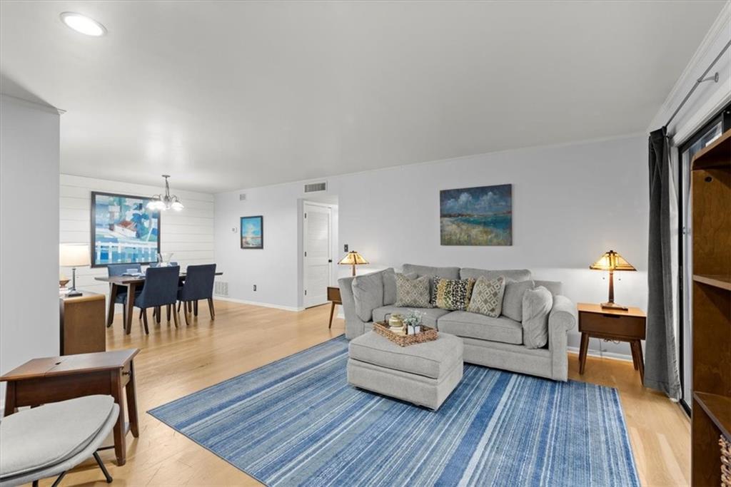 Living room featuring an inviting chandelier and light wood-type flooring