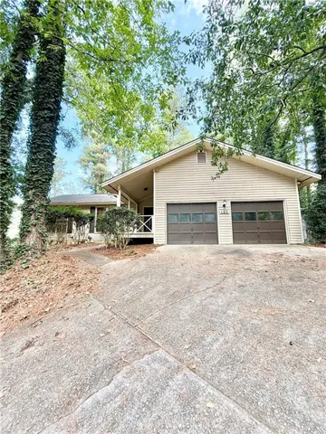 Siding exterior with a gable roof, two-car garage, and a covered porch with white railing