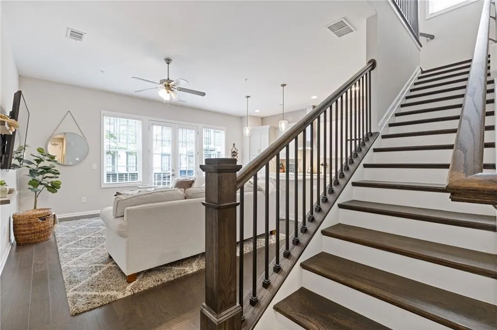Staircase with wood finished floors and a ceiling fan