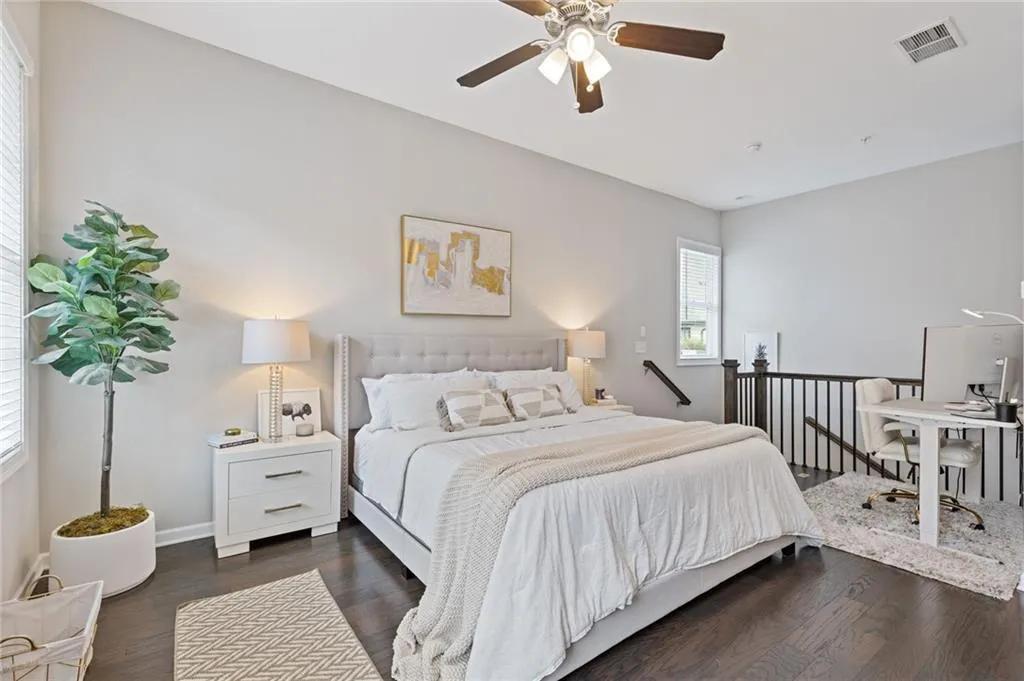 Bedroom featuring dark wood-style flooring, a ceiling fan, and a desk