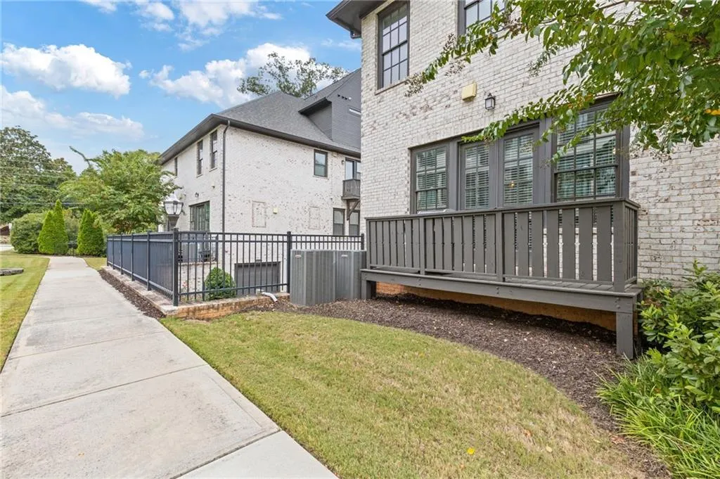 View of property exterior with brick siding and a deck