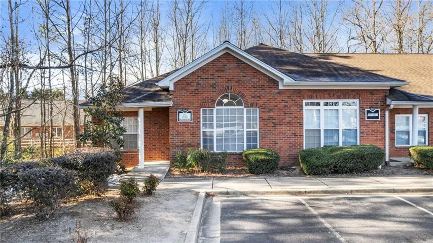 Single story home with a shingled roof and brick siding