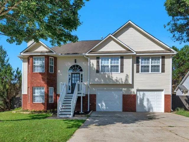 Exterior featuring a blend of brick and siding, a covered front entry with an arched transom, a two-car garage, and a concrete driveway