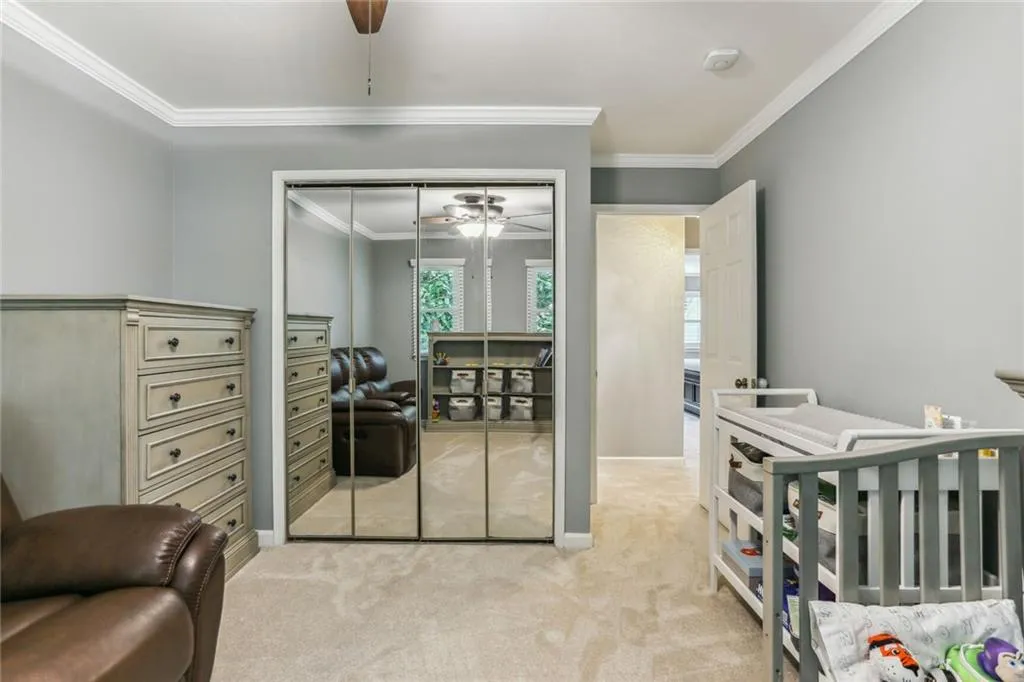 Carpeted bedroom with a closet, crown molding, and ceiling fan Carpeted bedroom with a closet, crown molding, and ceiling fan