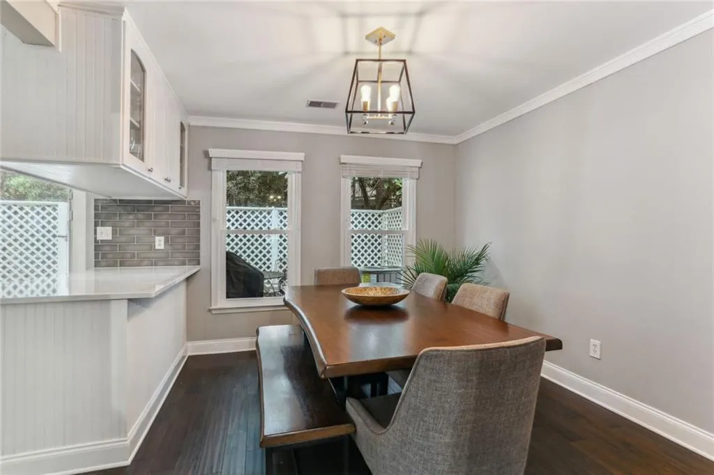 Dining room featuring a chandelier, crown molding, and dark hardwood / wood-style flooring Dining room featuring a chandelier, crown molding, and dark hardwood / wood-style flooring