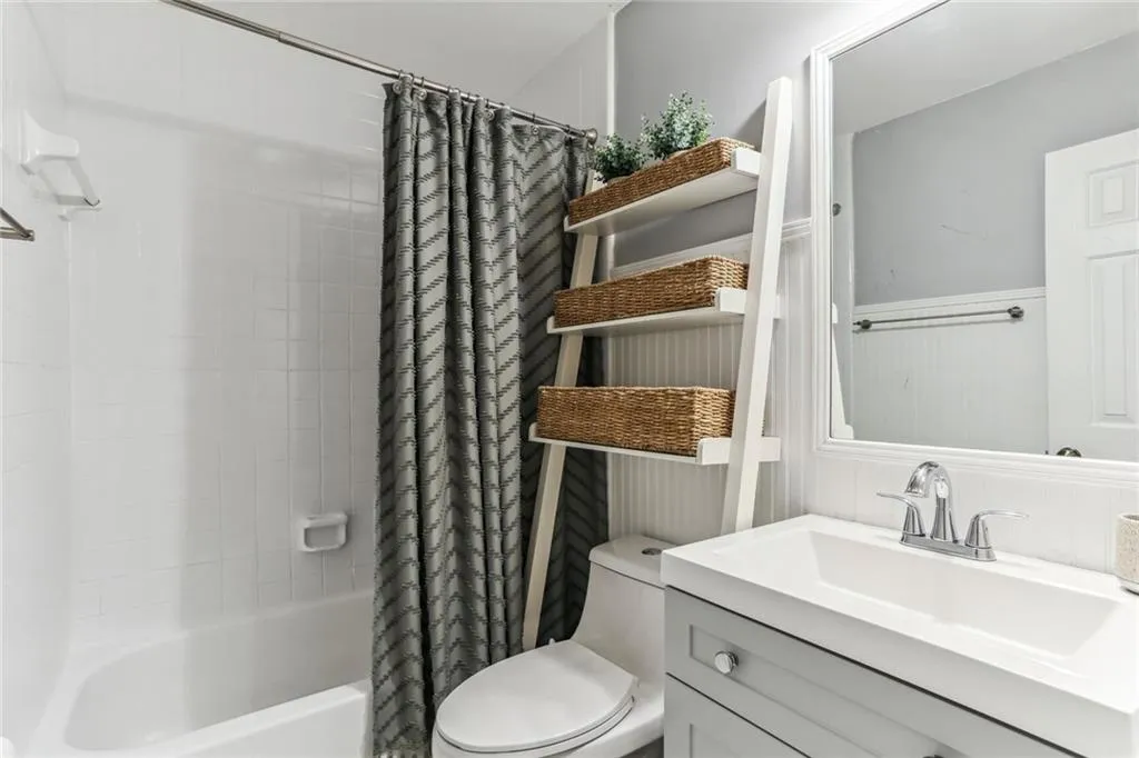 Full bathroom with vanity, shower / bath combo, and toilet Full bathroom with vanity, shower / bath combo, and toilet