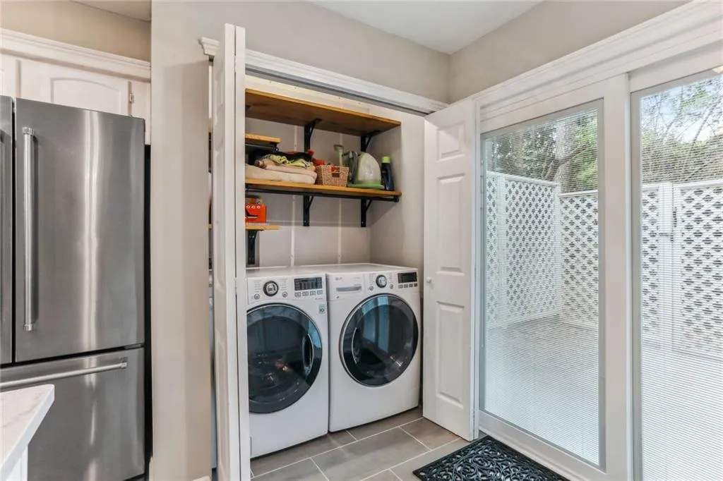 Laundry area with washing machine and dryer and light tile floors Laundry area with washing machine and dryer and light tile floors