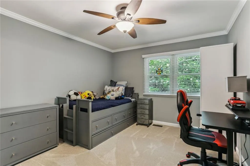 Carpeted bedroom with crown molding and ceiling fan Carpeted bedroom with crown molding and ceiling fan