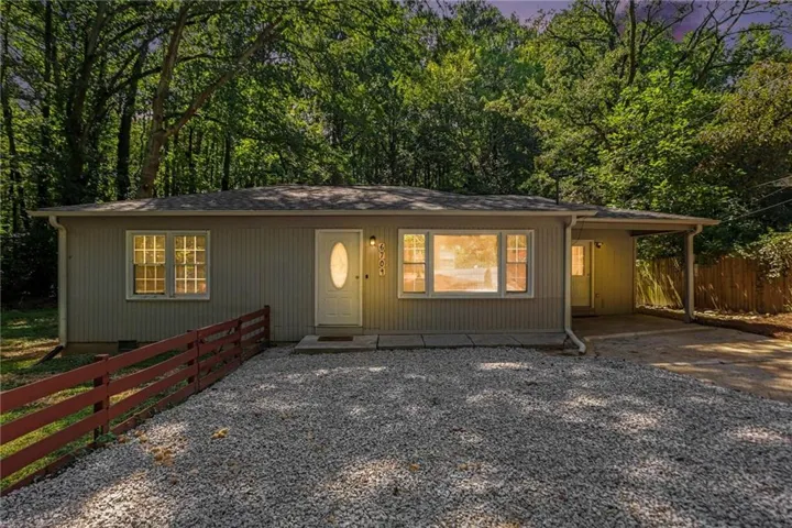 Single-story residence featuring light gray siding, white-framed windows, and a covered entryway