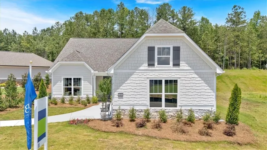 View of front of home with a front lawn and a shingled roof