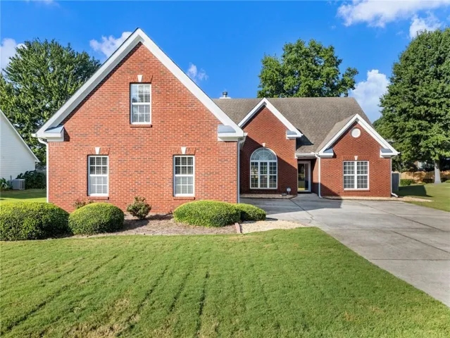 Brick exterior with white trim, arched window, and gabled roofline