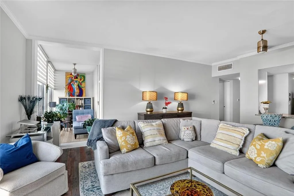 Living room featuring crown molding and wood finished floors Living room featuring crown molding and wood finished floors