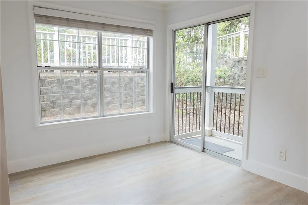 Empty room with light hardwood / wood-style floors and a healthy amount of sunlight