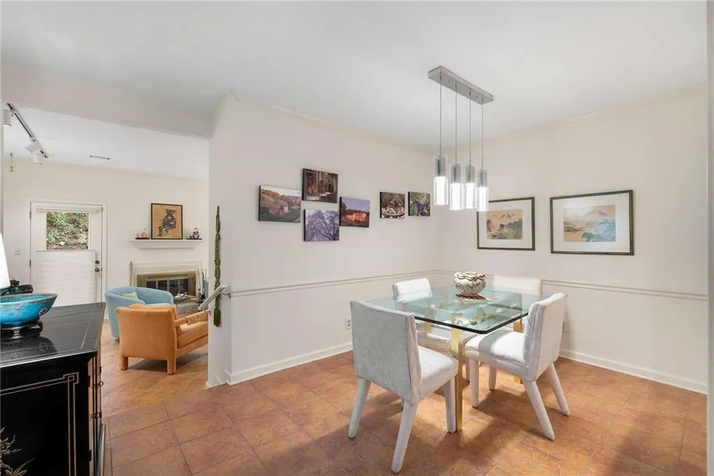 Dining room with crown molding, track lighting, a glass covered fireplace, a chandelier, and baseboards