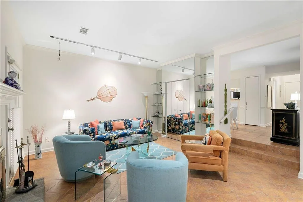 Living room featuring ornamental molding, visible vents, and rail lighting