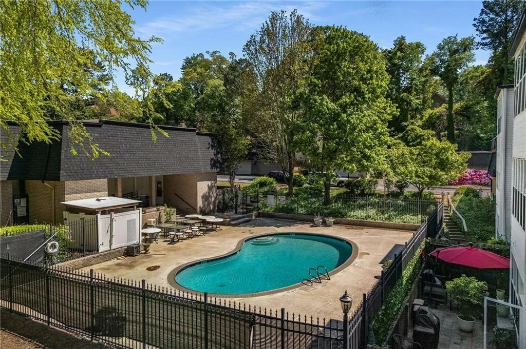 Pool with a patio area and fence
