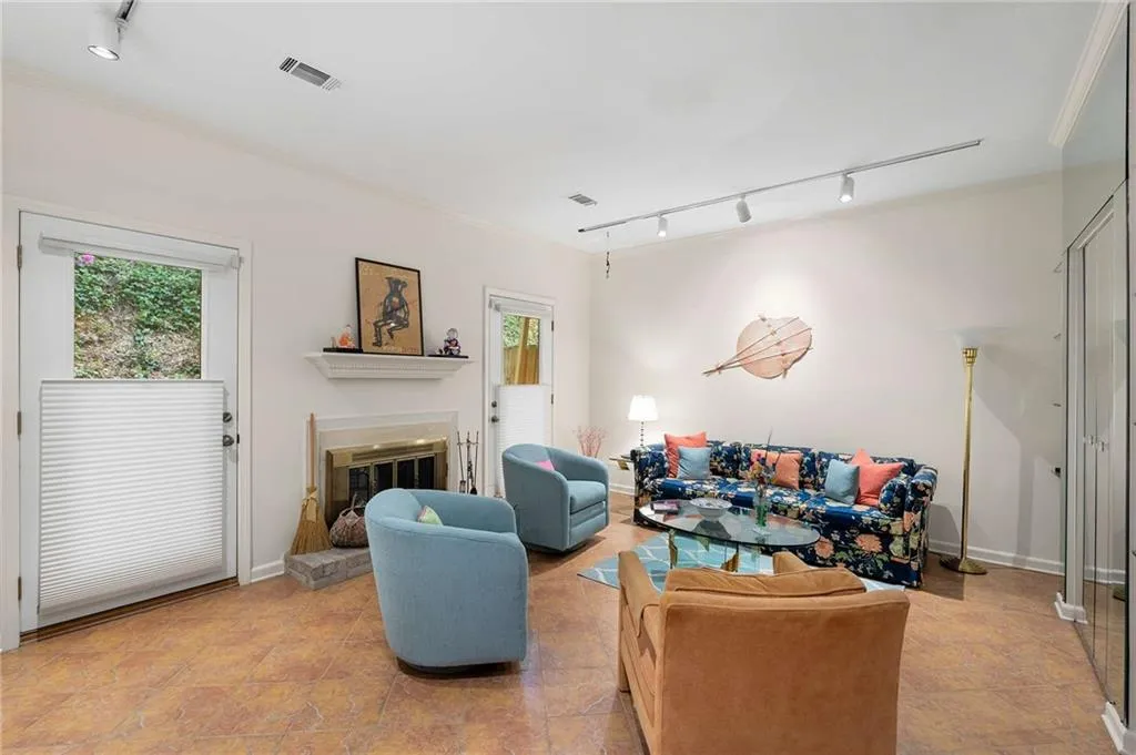 Living area featuring visible vents, a wealth of natural light, rail lighting, and a glass covered fireplace