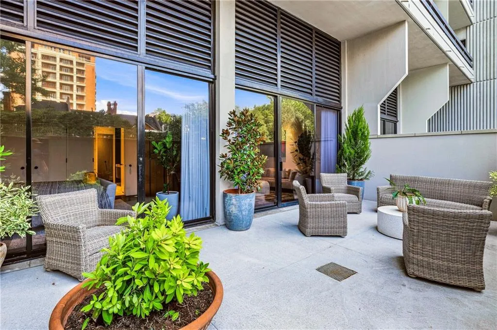 Expansive private patio with concrete flooring and multiple large planters