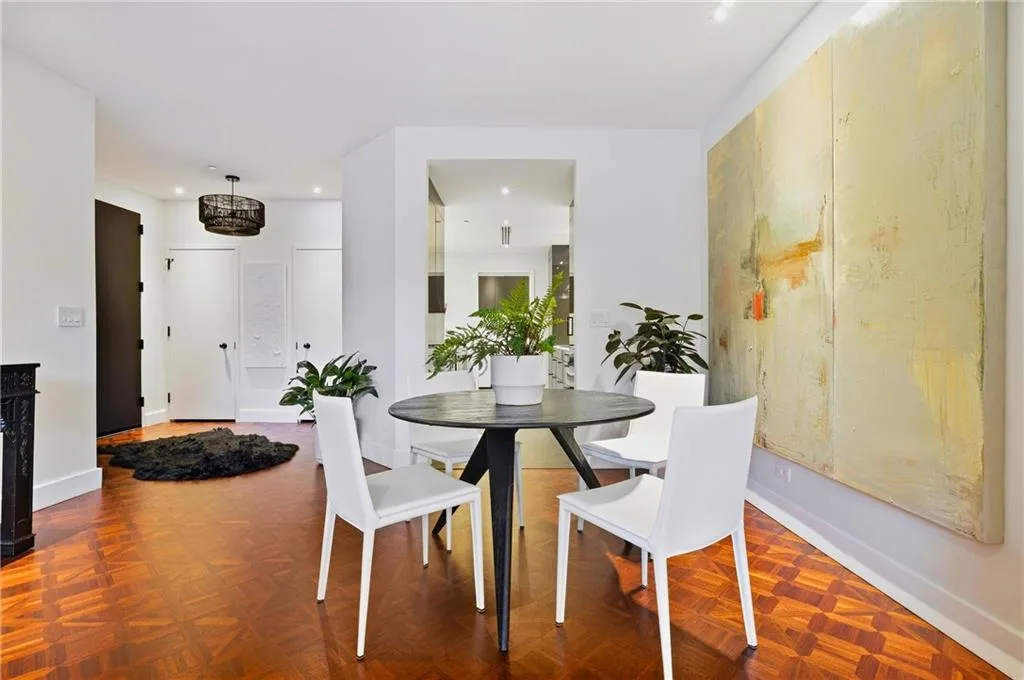 Hardwood flooring with a patterned inlay, white walls, and a black decorative pendant light fixture