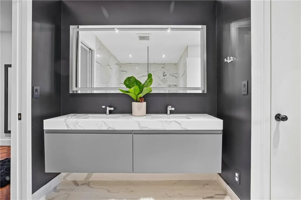 Floating vanity with dual integrated sinks, white countertop, and dark gray cabinetry